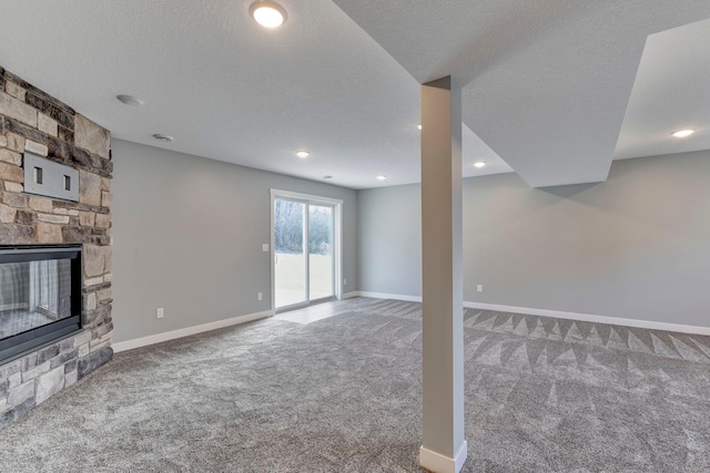 unfurnished living room featuring a stone fireplace, carpet, and a textured ceiling