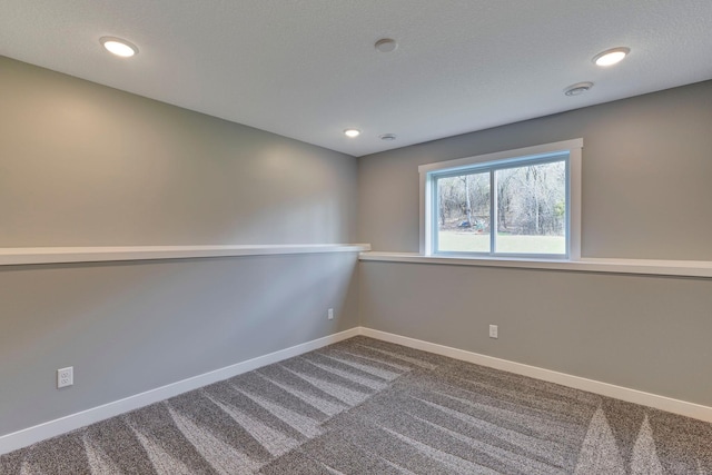 carpeted spare room with a textured ceiling