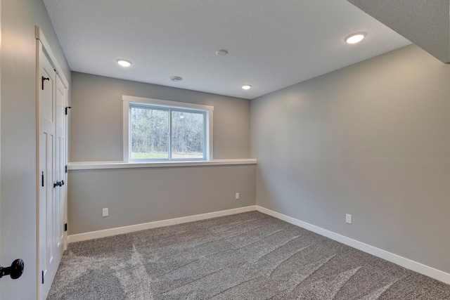 carpeted spare room with a textured ceiling