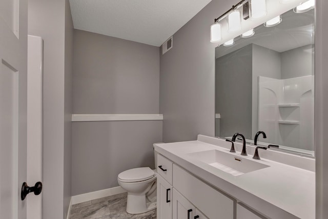 bathroom featuring toilet, vanity, a textured ceiling, and walk in shower