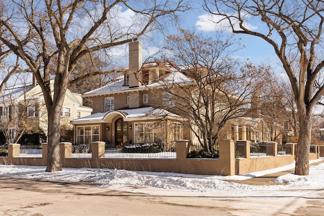 view of front of house featuring a fenced front yard and a chimney