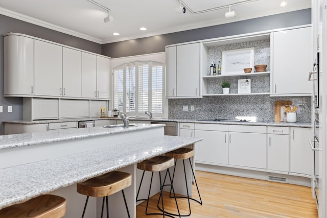 kitchen featuring open shelves, a breakfast bar, black electric cooktop, and white cabinets