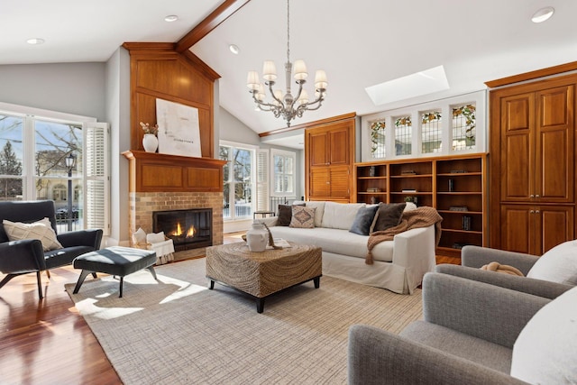 living room featuring a fireplace, light wood finished floors, an inviting chandelier, high vaulted ceiling, and beamed ceiling