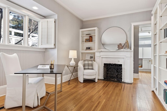 home office with wallpapered walls, a fireplace with flush hearth, baseboards, and light wood-style flooring