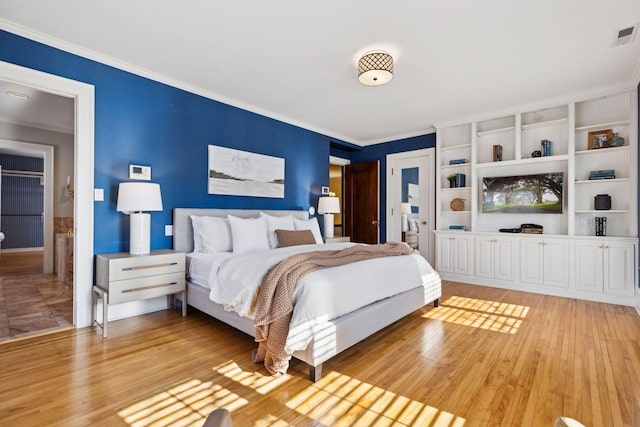 bedroom with ornamental molding and light wood-style floors