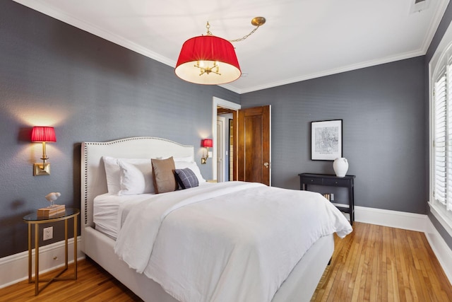 bedroom featuring baseboards, wood finished floors, and ornamental molding