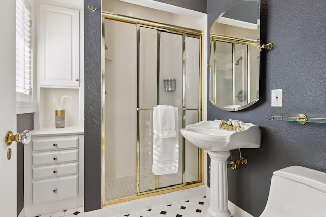 bathroom featuring a textured wall, a stall shower, and toilet