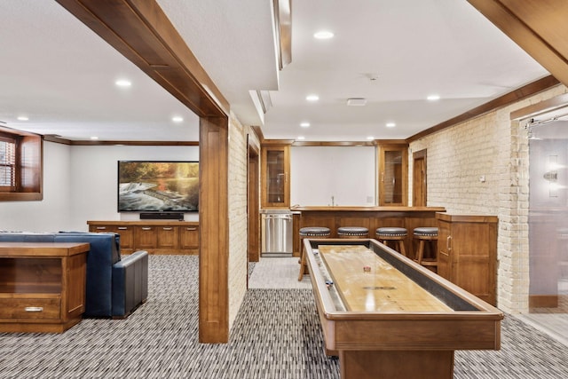 game room featuring light colored carpet, brick wall, crown molding, indoor wet bar, and recessed lighting