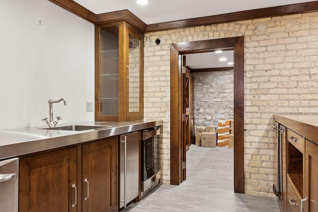 bar with dishwasher, ornamental molding, a sink, and light wood-style flooring