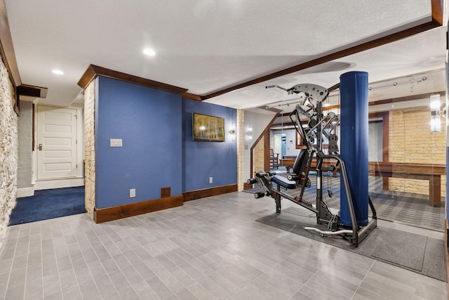 workout area with a textured ceiling and baseboards