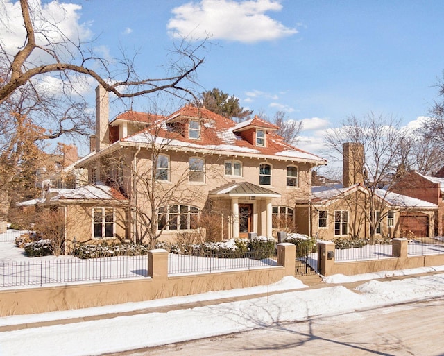 traditional style home featuring a fenced front yard and a chimney