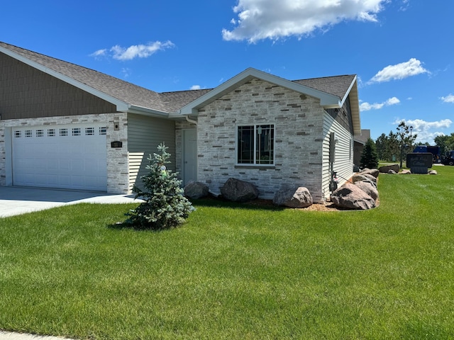 1615 30th St NW Unit 31, Bemidji, MN 56601 - ranch-style house featuring driveway, a garage, a shingled roof, stone siding, and a front lawn