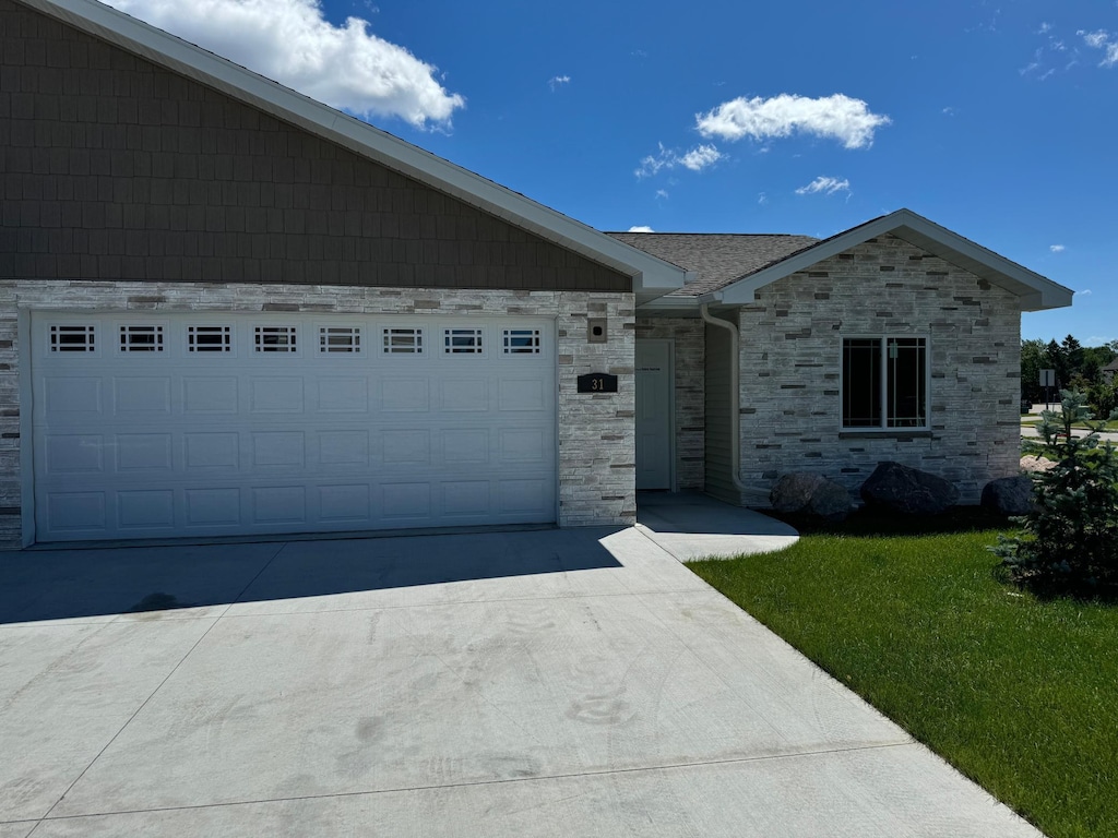 1615 30th St NW Unit 31, Bemidji, MN 56601 - single story home with stone siding, a front lawn, driveway, and an attached garage