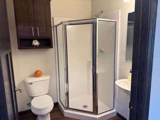 1615 30th St NW Unit 31, Bemidji, MN 56601 - bathroom with toilet, a stall shower, wood finished floors, and a textured wall