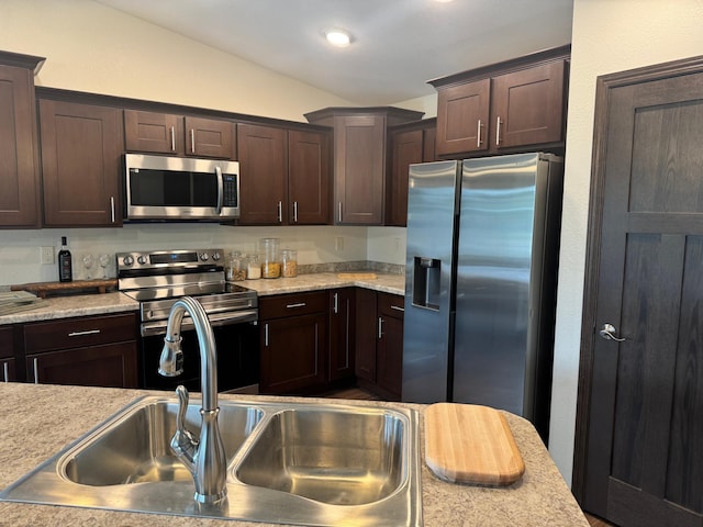 1615 30th St NW Unit 31, Bemidji, MN 56601 - kitchen with appliances with stainless steel finishes, dark brown cabinets, vaulted ceiling, and a sink