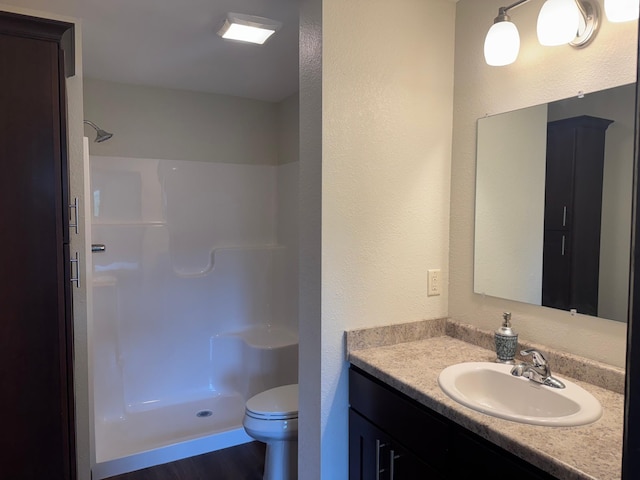 1615 30th St NW Unit 31, Bemidji, MN 56601 - full bath featuring a shower stall, vanity, toilet, wood finished floors, and a textured wall