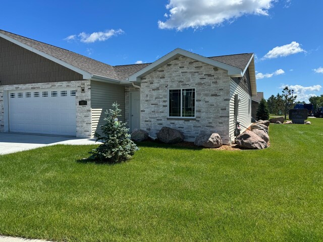 1615 30th St NW Unit 31, Bemidji, MN 56601 - single story home with stone siding, a garage, a front yard, driveway, and a shingled roof