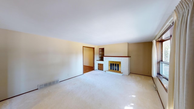 unfurnished living room with light carpet and a fireplace