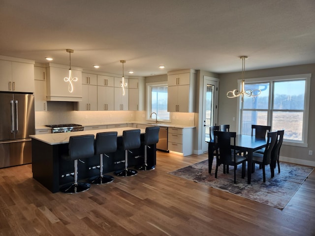 kitchen featuring pendant lighting, white cabinetry, appliances with stainless steel finishes, and a kitchen island