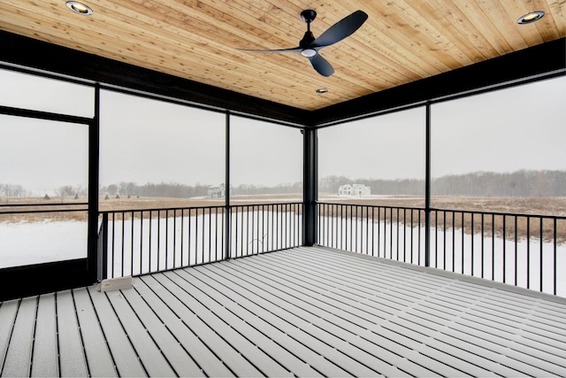 unfurnished sunroom with ceiling fan, a water view, and wood ceiling