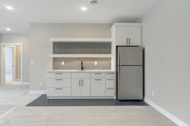 kitchen featuring tasteful backsplash, sink, stainless steel fridge, and dark carpet