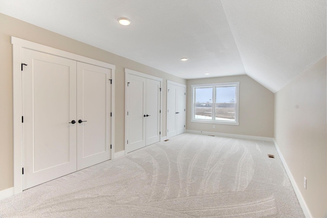 bonus room featuring vaulted ceiling and light colored carpet