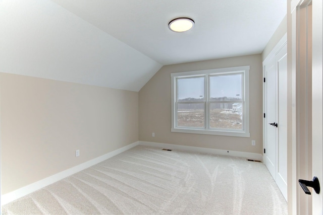 bonus room featuring vaulted ceiling and light carpet