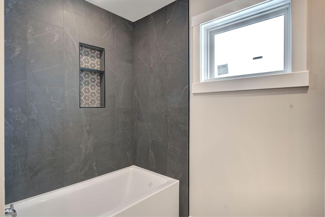 bathroom featuring tiled shower / bath