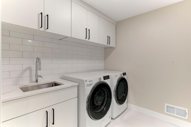 washroom featuring cabinets, sink, and independent washer and dryer