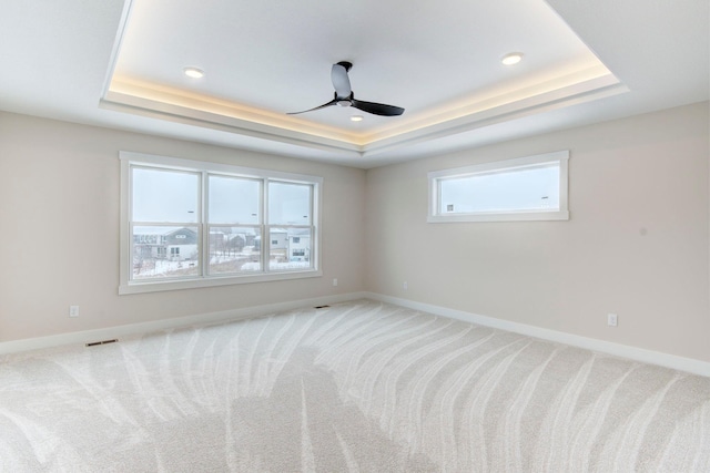 unfurnished room featuring carpet floors, ceiling fan, and a tray ceiling