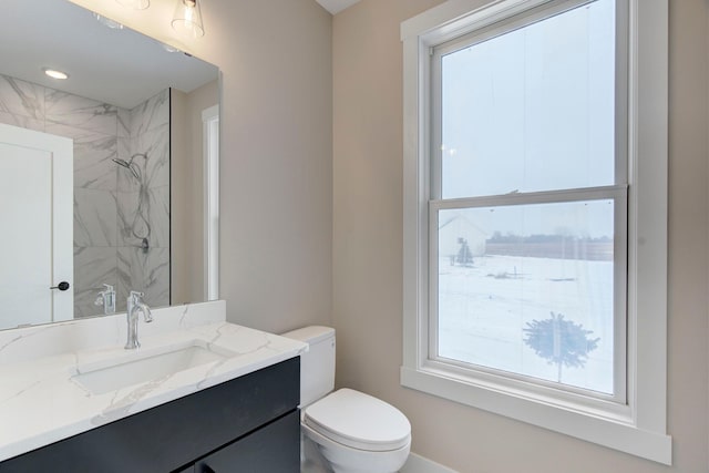 bathroom featuring vanity, tiled shower, and toilet