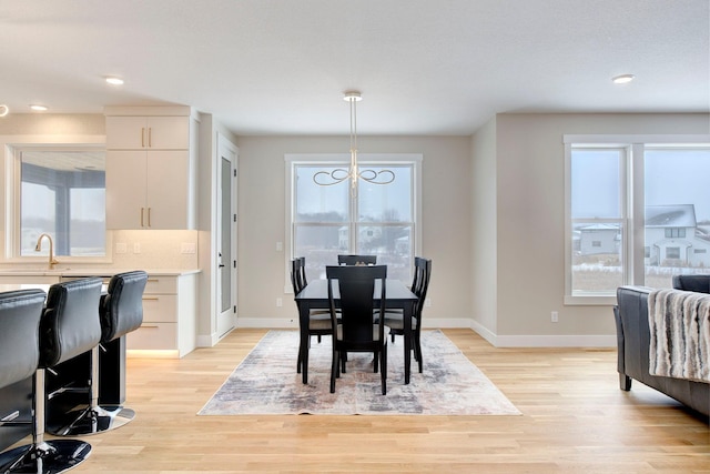 dining space with sink and light hardwood / wood-style floors