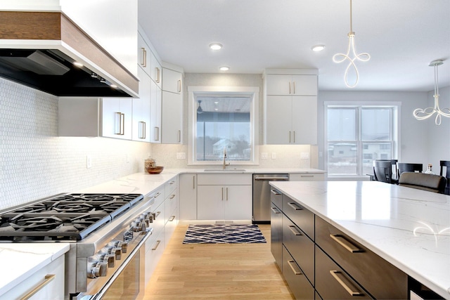 kitchen with stainless steel appliances, custom range hood, hanging light fixtures, and white cabinets