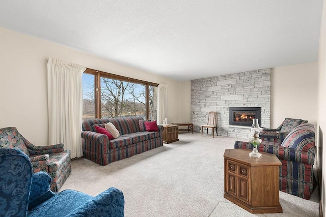 carpeted living room with a stone fireplace