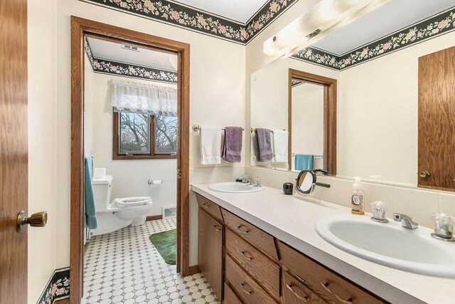 bathroom with a bidet, toilet, tile patterned floors, and double vanity