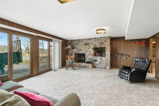 living room featuring a fireplace, carpet, and wooden walls