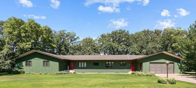 ranch-style house with a garage and a front lawn