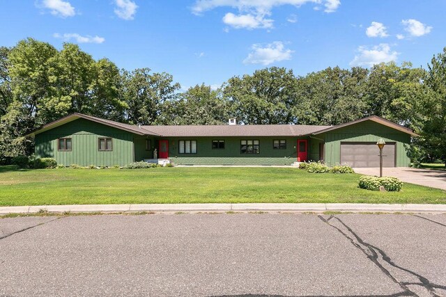 ranch-style house featuring a garage and a front yard