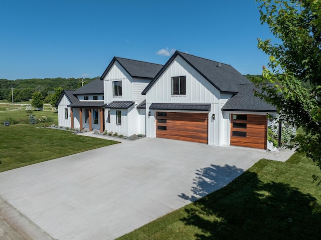 modern farmhouse style home featuring a front lawn and a garage