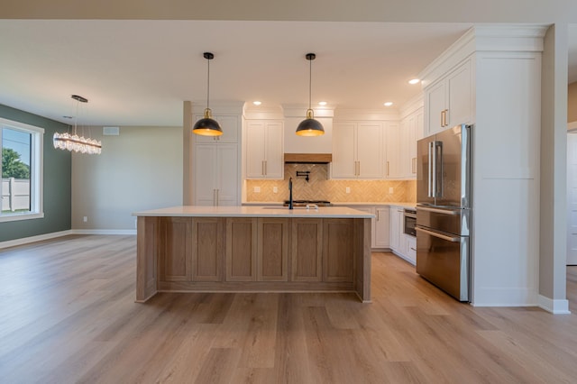 kitchen with white cabinetry, a center island with sink, and high end fridge