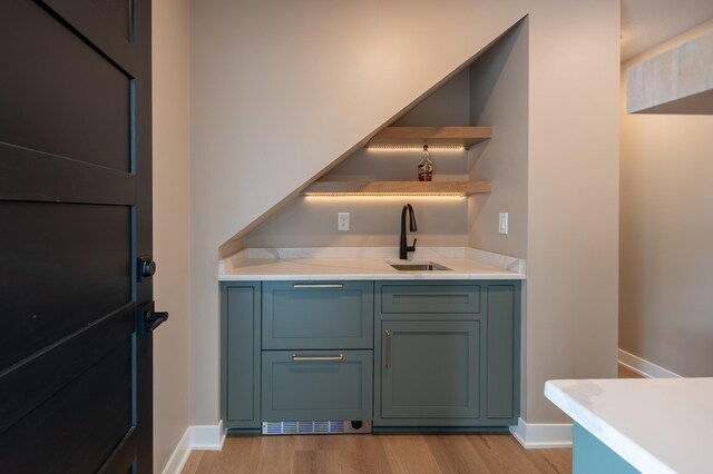 bar featuring sink and light hardwood / wood-style floors