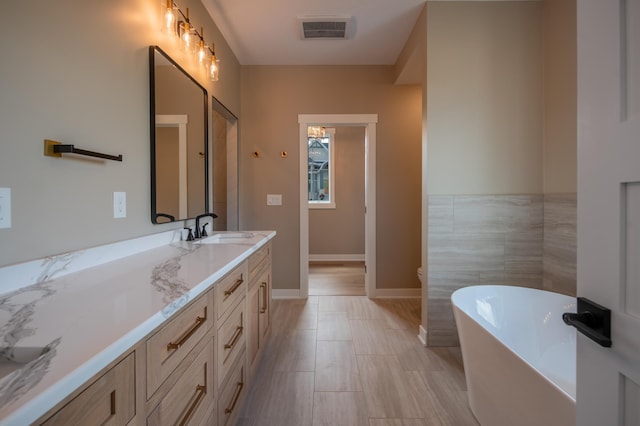 bathroom featuring a tub to relax in and vanity