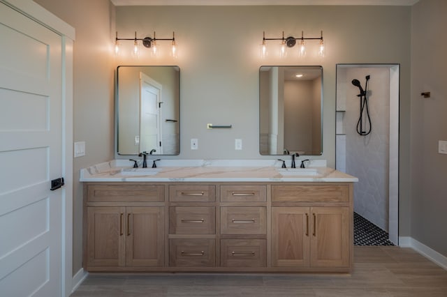 bathroom with tiled shower and vanity