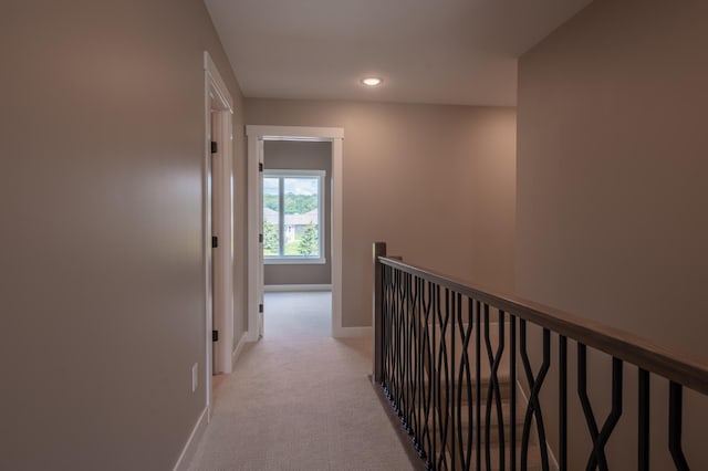 hallway featuring light colored carpet