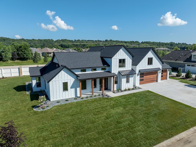 modern farmhouse style home with a front lawn, central air condition unit, covered porch, and a garage