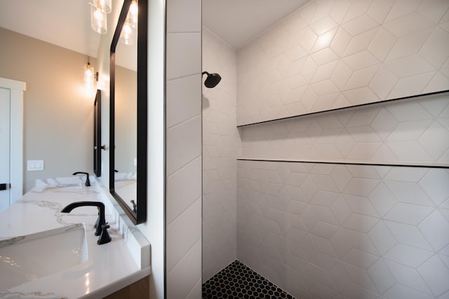 bathroom with tiled shower and vanity