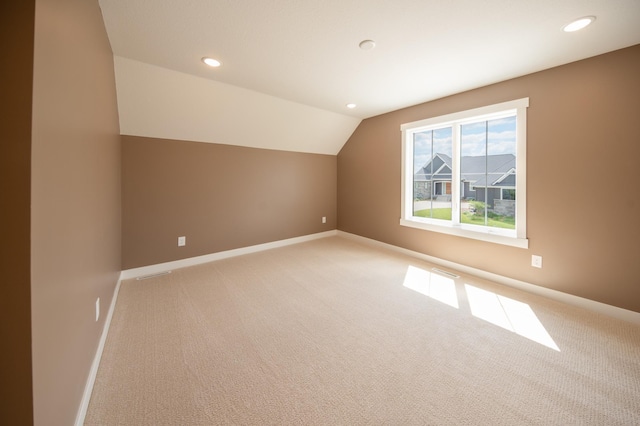 additional living space featuring light carpet and lofted ceiling