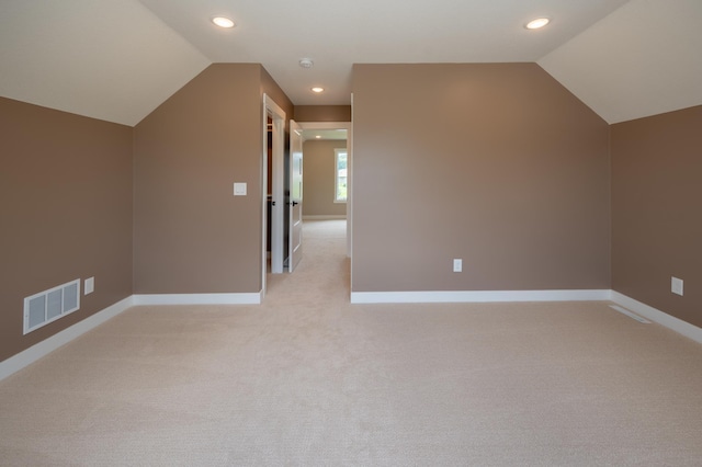 additional living space featuring lofted ceiling and light colored carpet