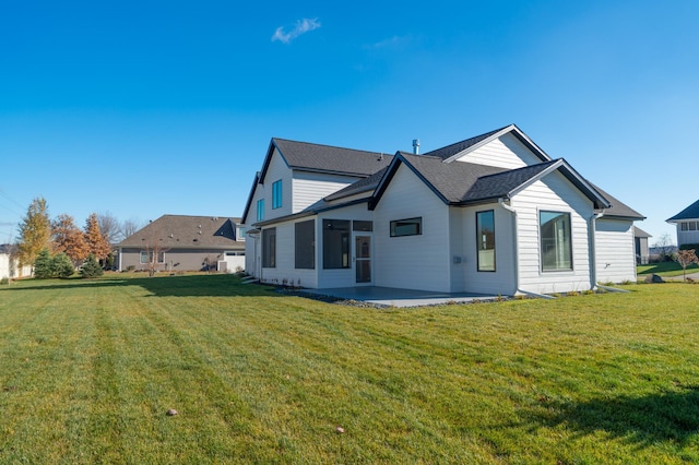 rear view of house featuring a lawn and a patio area