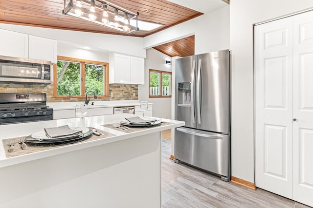 kitchen featuring light wood-type flooring, tasteful backsplash, vaulted ceiling, appliances with stainless steel finishes, and wooden ceiling